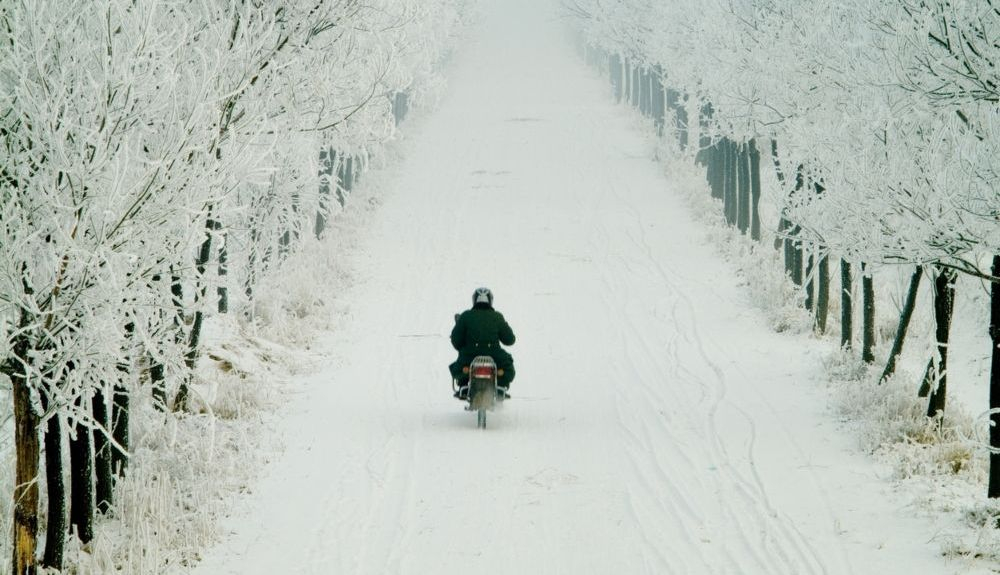 Motorista, con sus pantalones de invierno, en plena carretera helada. Fuente: iStock / Black-White