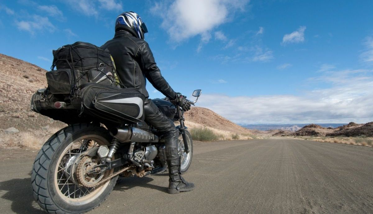 Motorista con su equipaje listo antes de practicar mototurismo. Fuente: iStock / RainervonBrandis