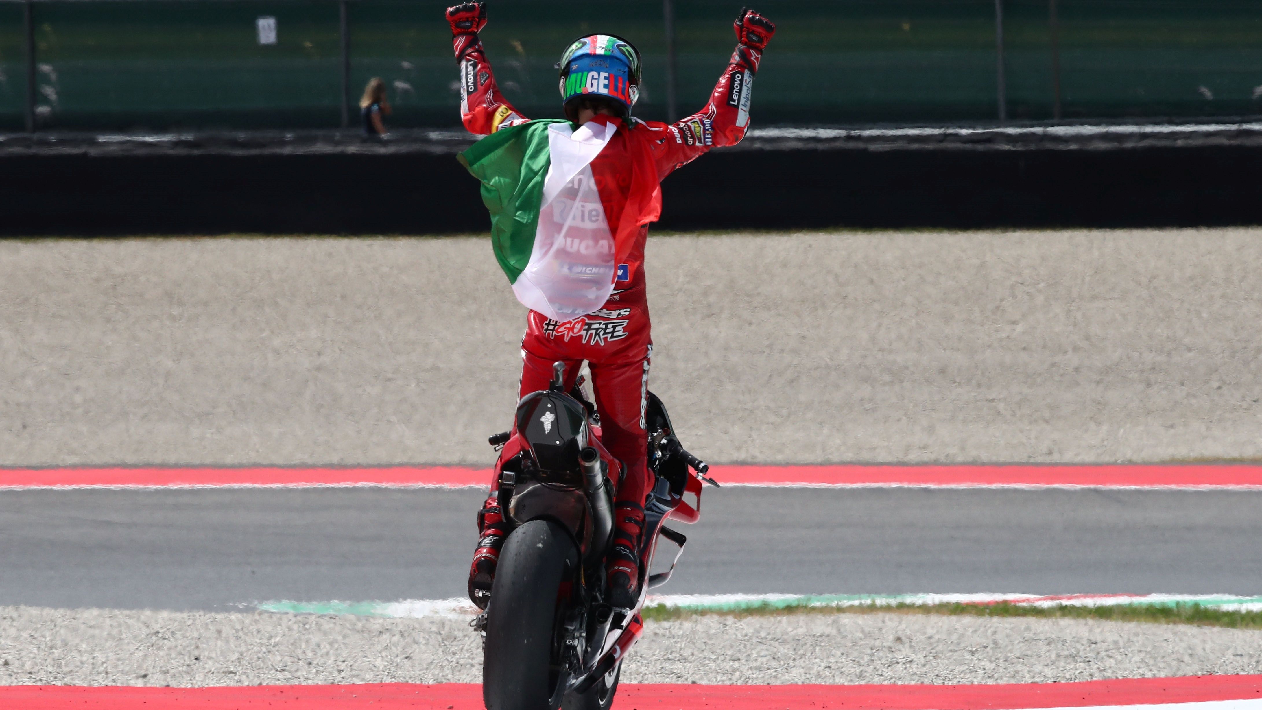 Pecco Bagnaia festeja su victoria en Mugello con la bandera italiana