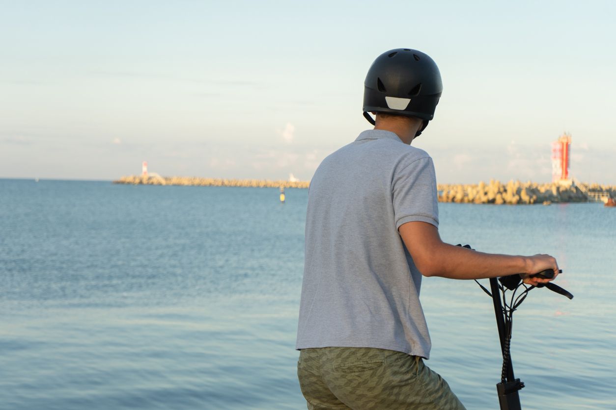 Un hombre con su casco para patinete eléctrico