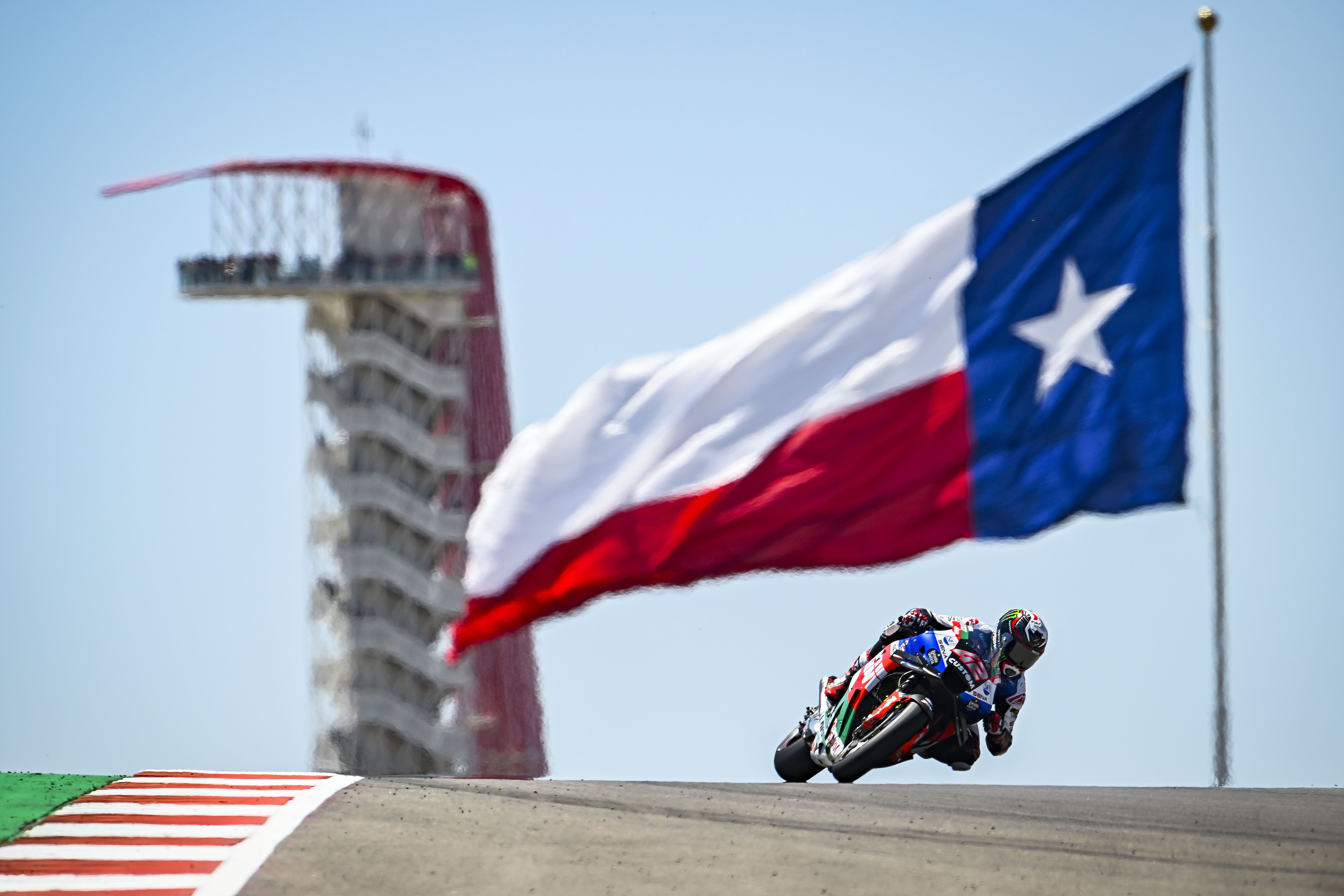 Álex Rins pasando bajo la bandera de Texas, MotoGP Américas 2023