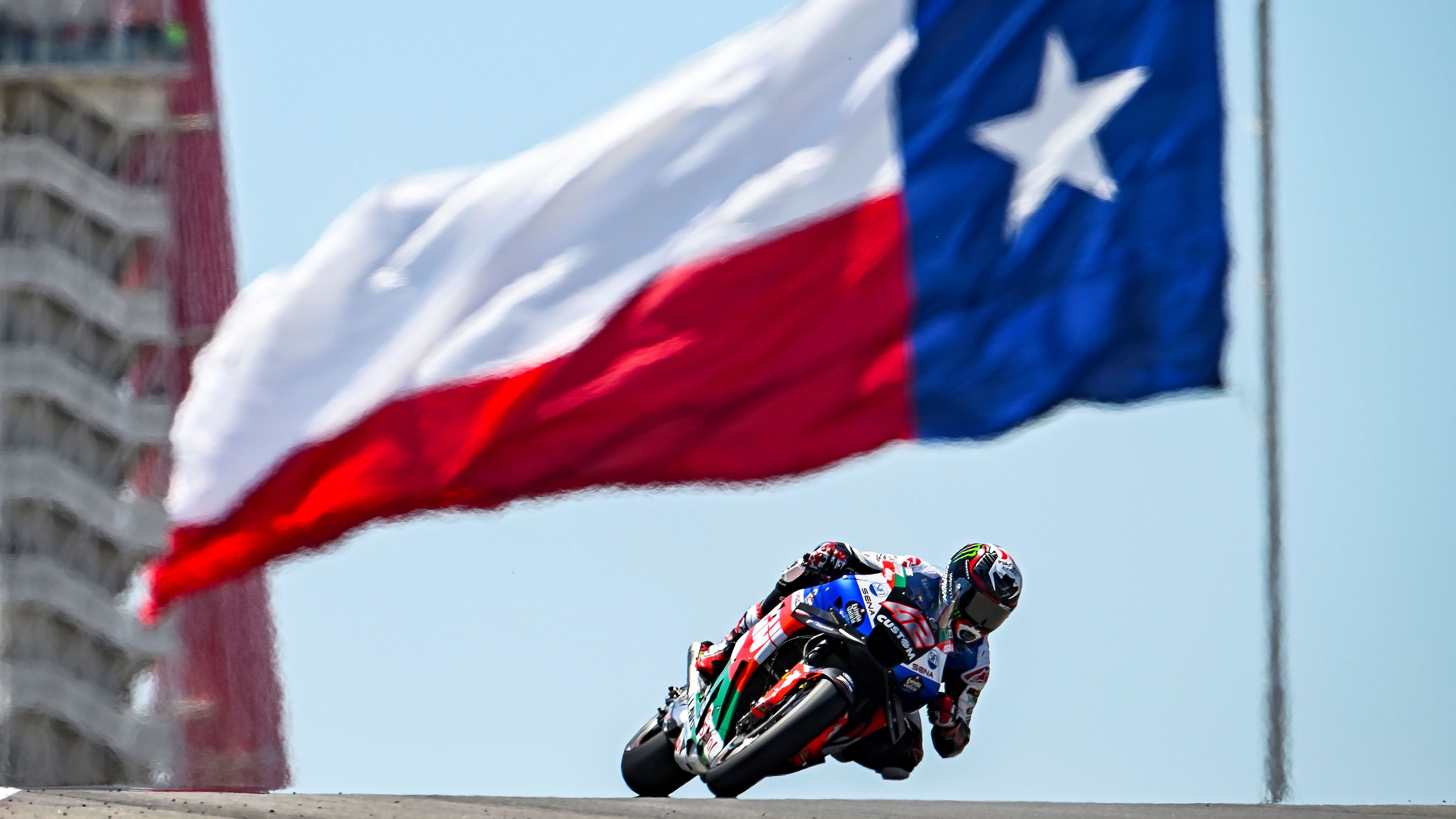 Álex Rins pasando bajo la bandera de Texas, el llamado estado de la estrella solitaria