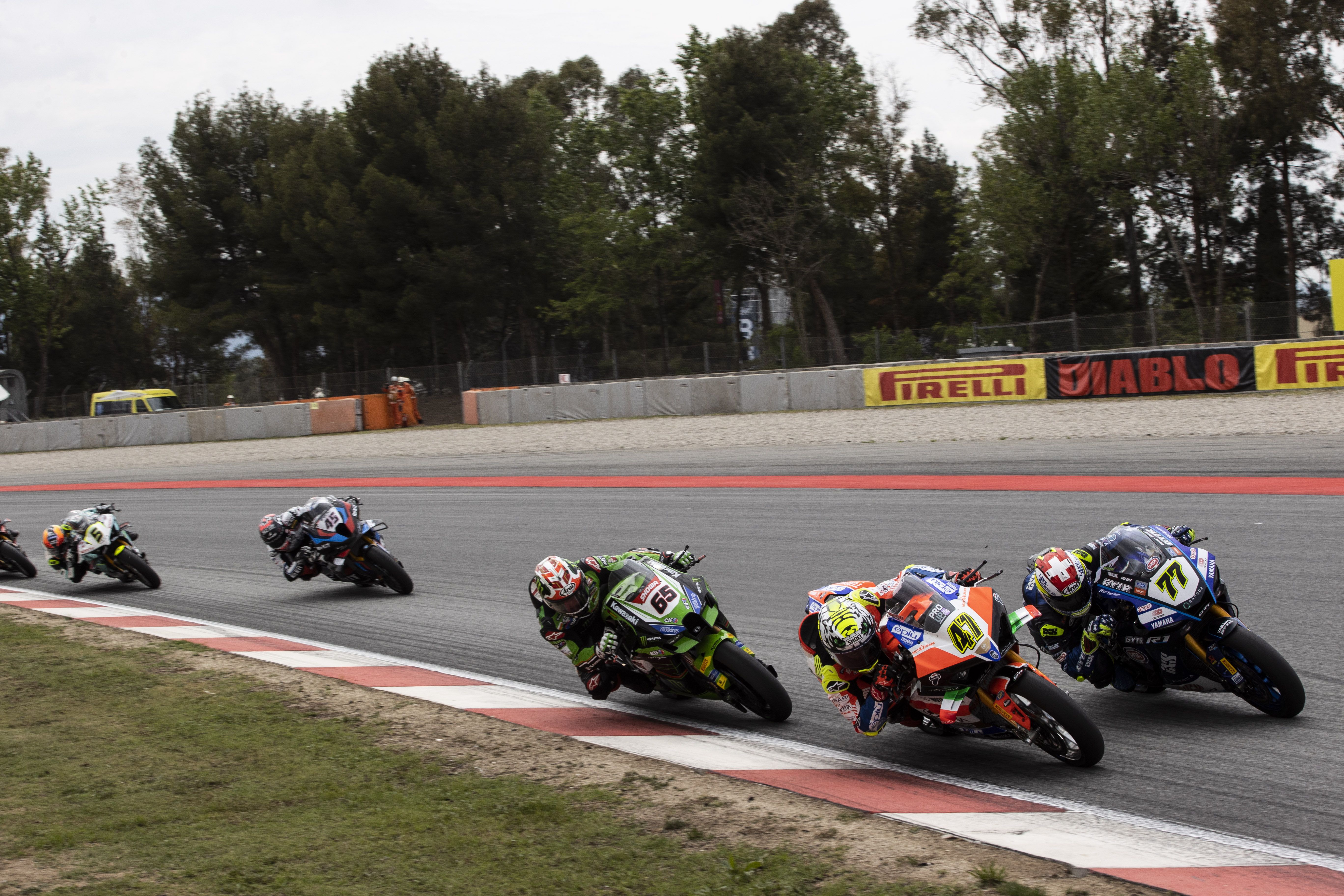 Axel Bassani mete la moto a Dominique Aegerter en presencia de Jonathan Rea, WSBK Barcelona 2023