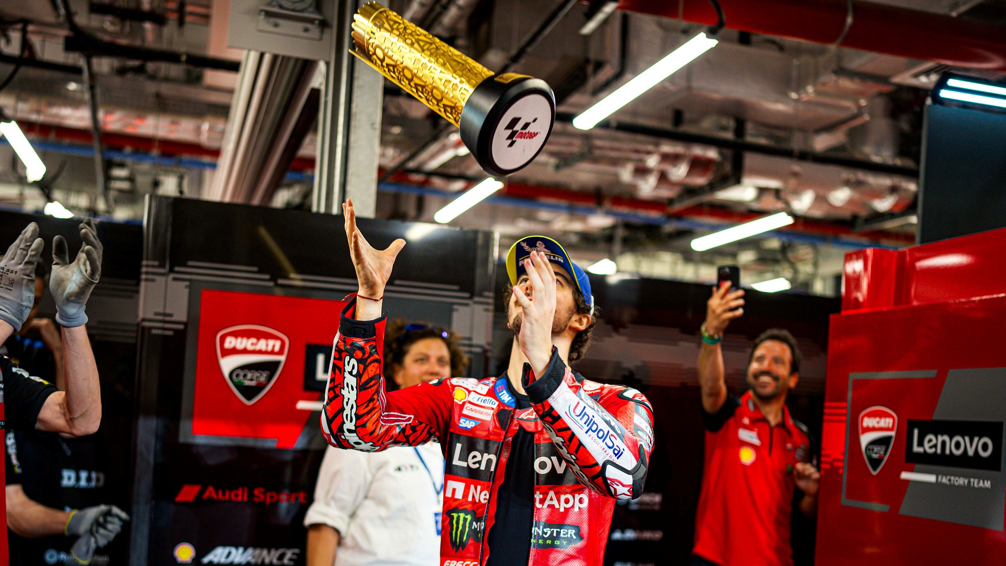 Pecco Bagnaia lanzando el trofeo de ganador del Gran Premio de Qatar de MotoGP 2024