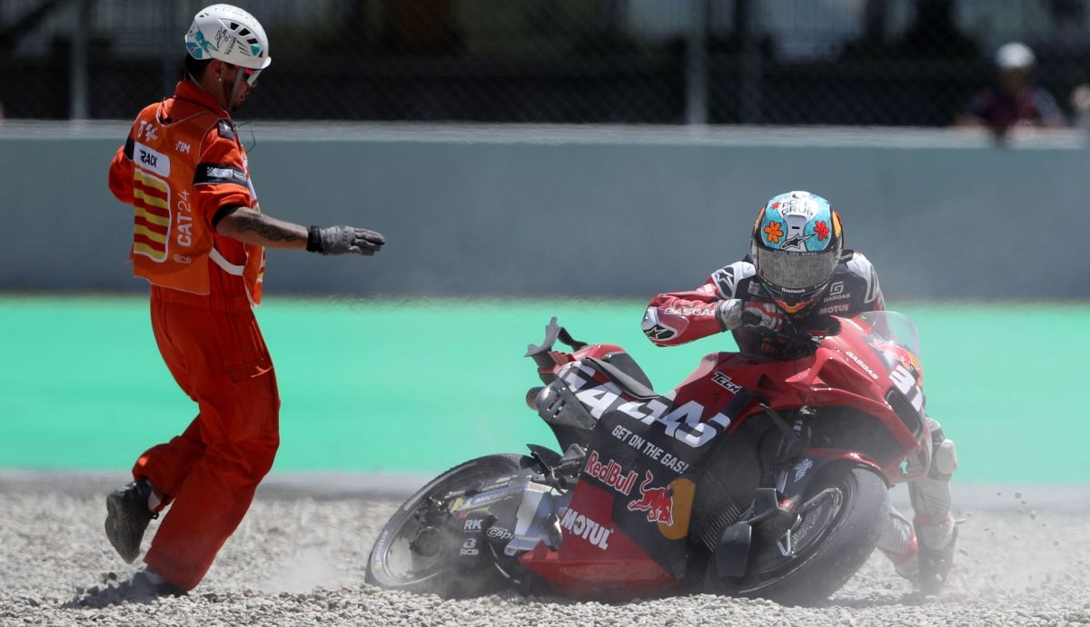 Pedro Acosta trata de levantar su moto tras caerse