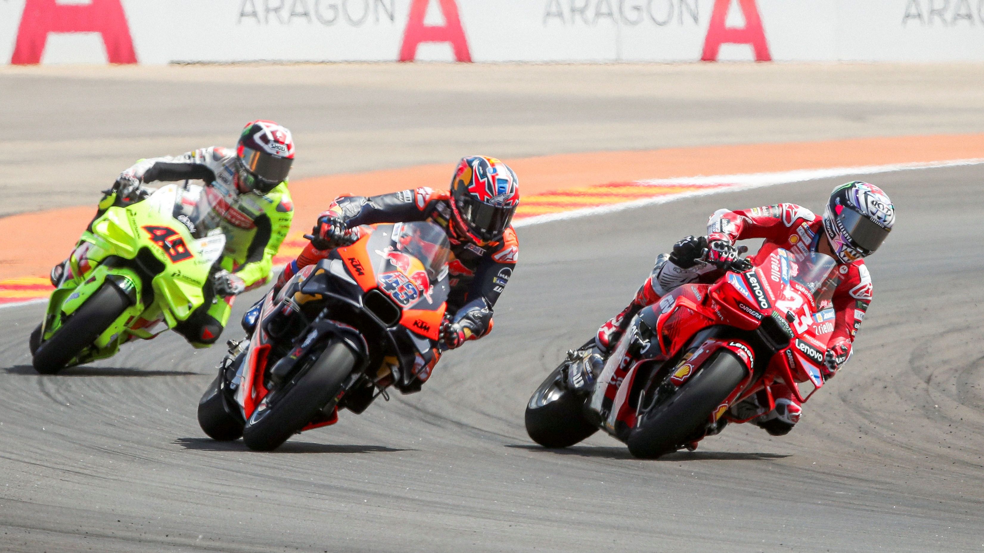 Enea Bastianini supera a Jack Miller ante la mirada de Fabio Di Giannantonio, MotoGP Aragón 2024