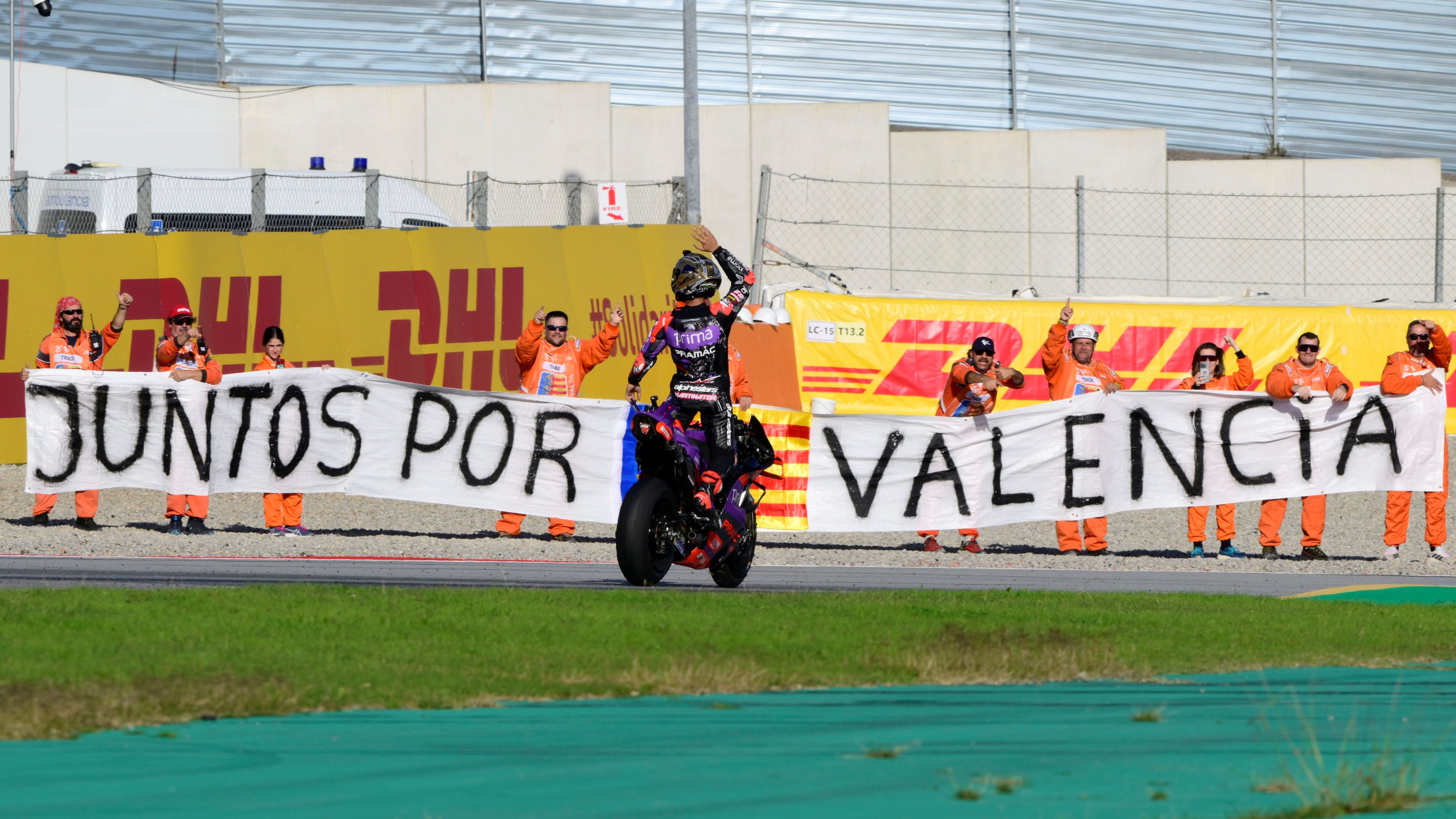Jorge Martín celebra el título ante la pancarta por Valencia, MotoGP Solidario 2024