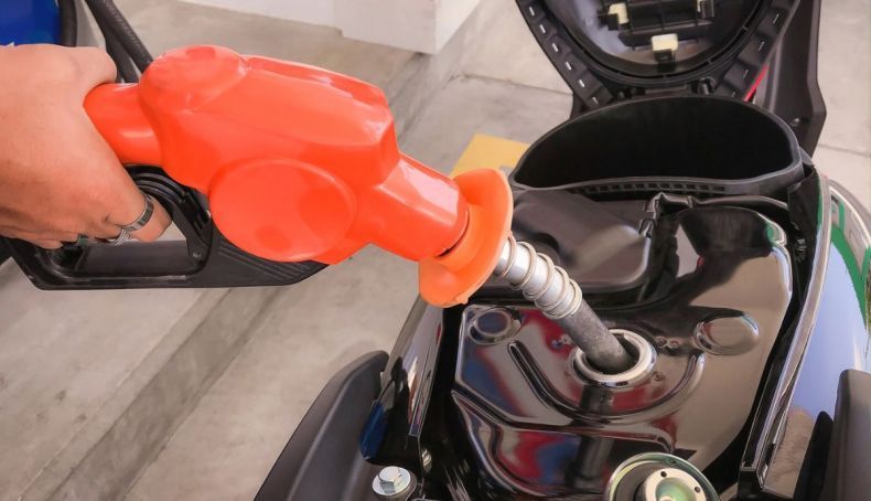 Una persona echando combustible en una moto