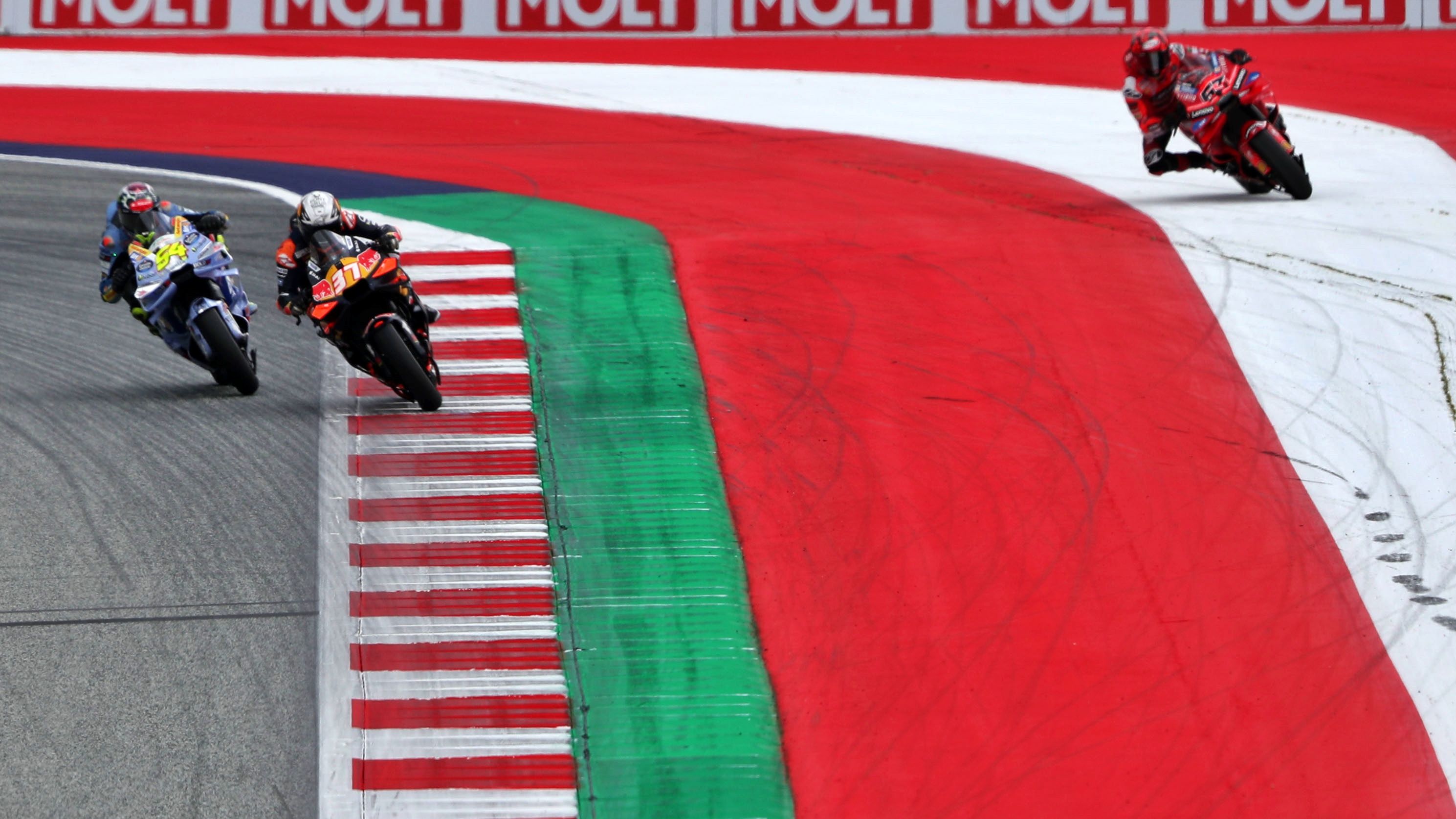 Pedro Acosta y Fermín Aldeguer con Pecco Bagnaia fuera de pista, MotoGP Austria 2025