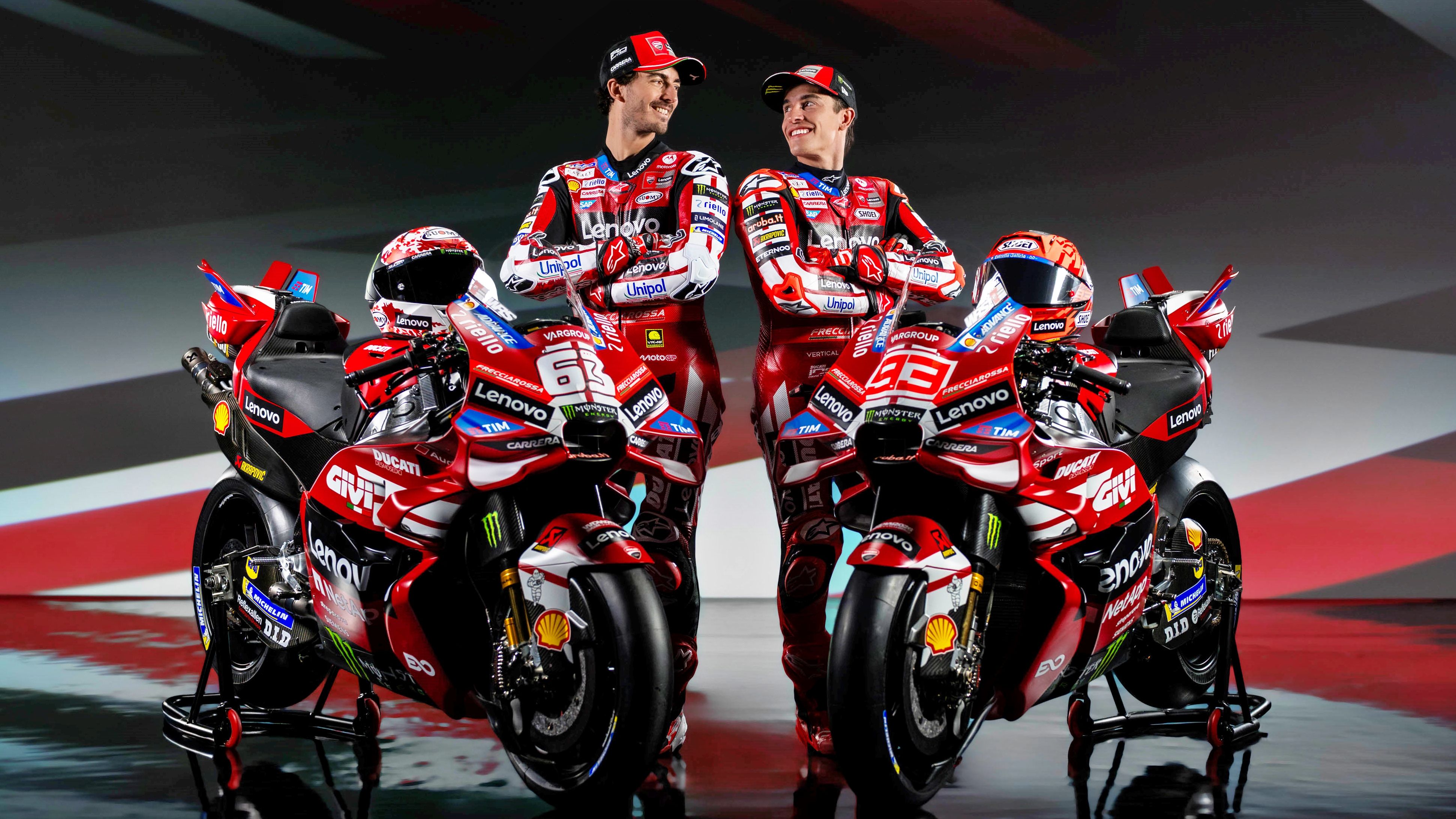 Pecco Bagnaia y Marc Márquez junto a las Ducati Desmosedici GP26 que llevarán en el Lenovo en MotoGP 2026