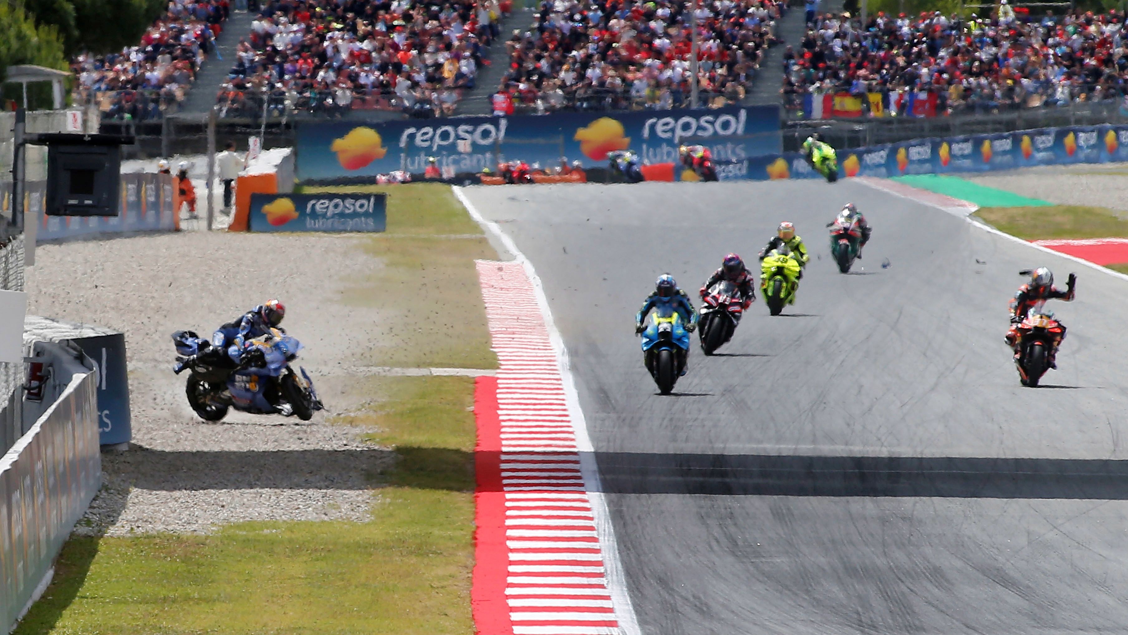 Álex Márquez intenta controlar su moto mientras Pedro Acosta levanta la mano, MotoGP Catalunya 2026