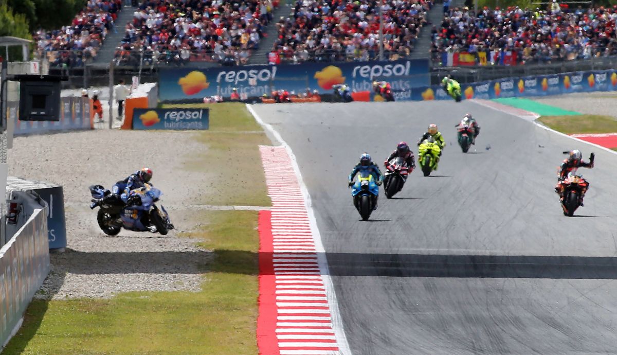 Álex Márquez intenta controlar su moto mientras Pedro Acosta levanta la mano, MotoGP Catalunya 2026