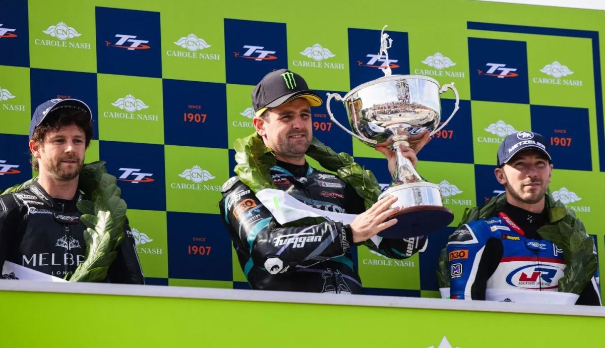 Michael Dunlop en el podio de Sportbike escoltado por Mike Browne y Paul Jordan