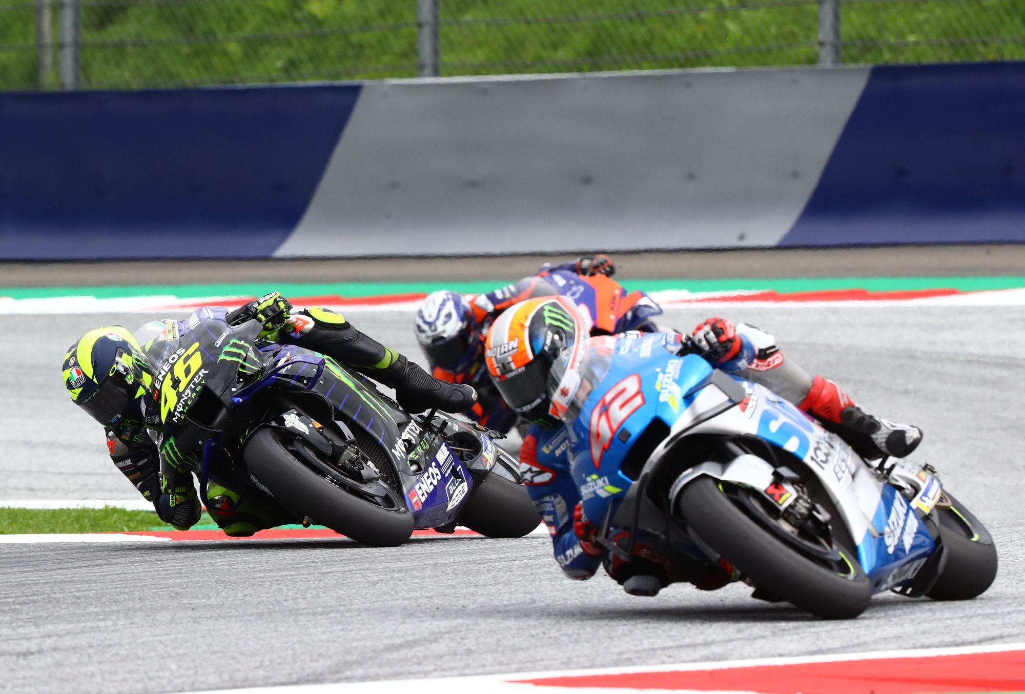 Álex Rins se va largo y Valentino Rossi va por el interior.