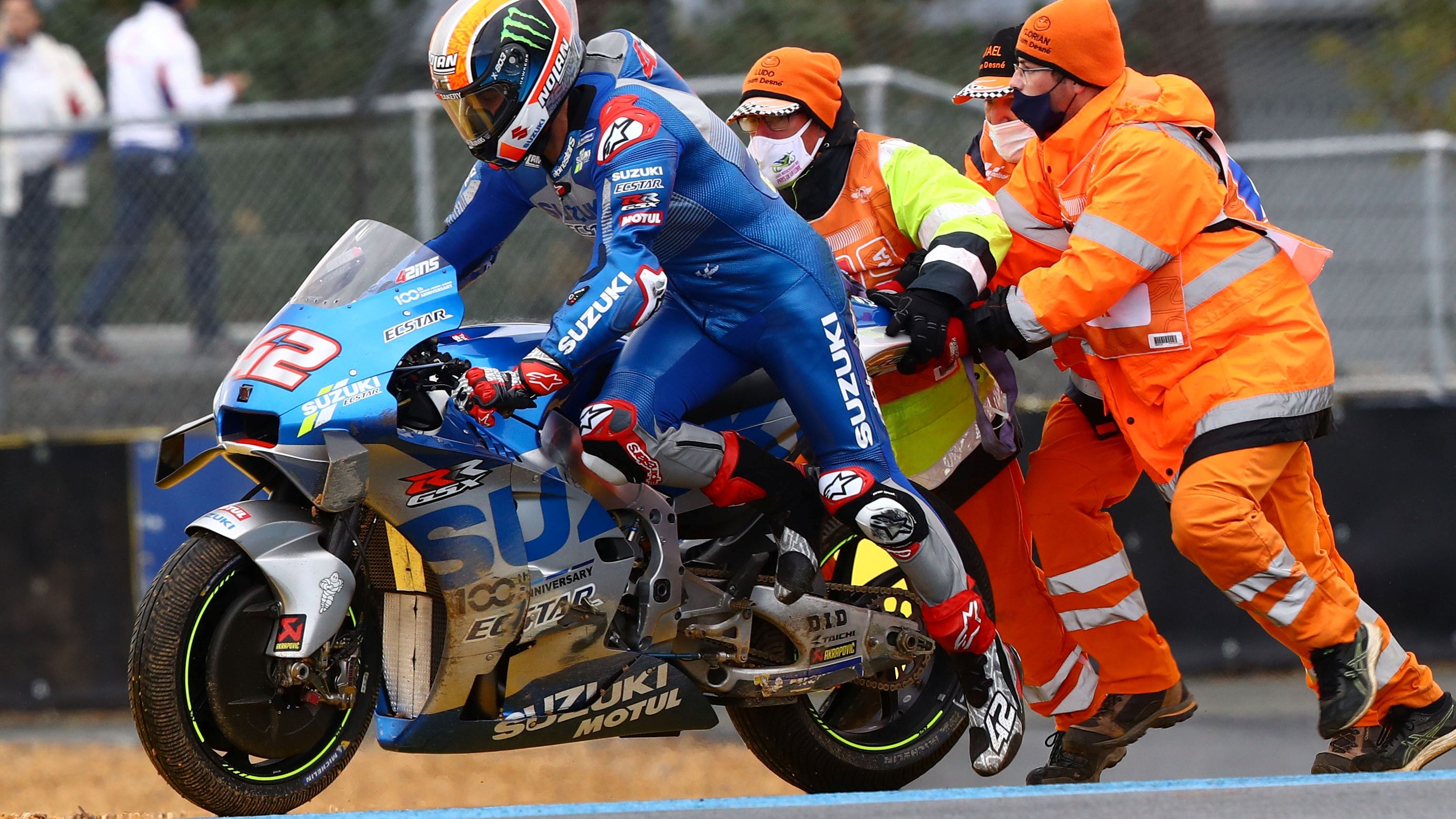 Álex Rins ayudado por los marshals para volver a carrera después de su caída