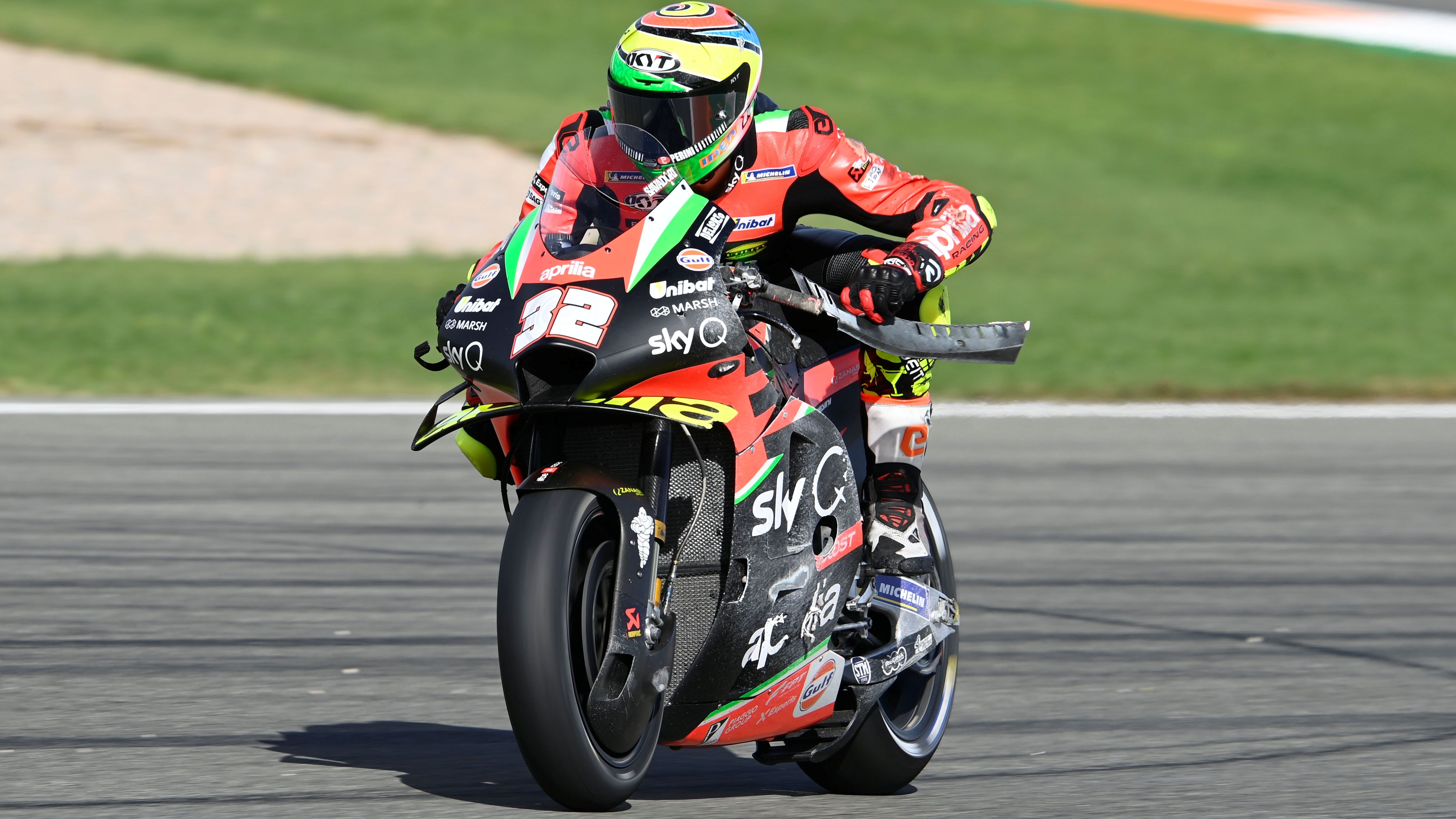 Lorenzo Savador intenta quitar alguna pieza de su Aprilia tras su caída