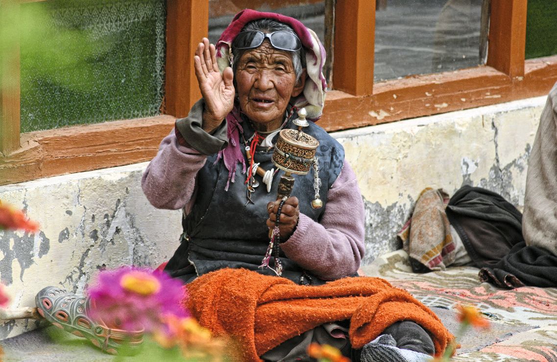 Viaje en moto al norte de la India.Una anciana con su rueda de oración