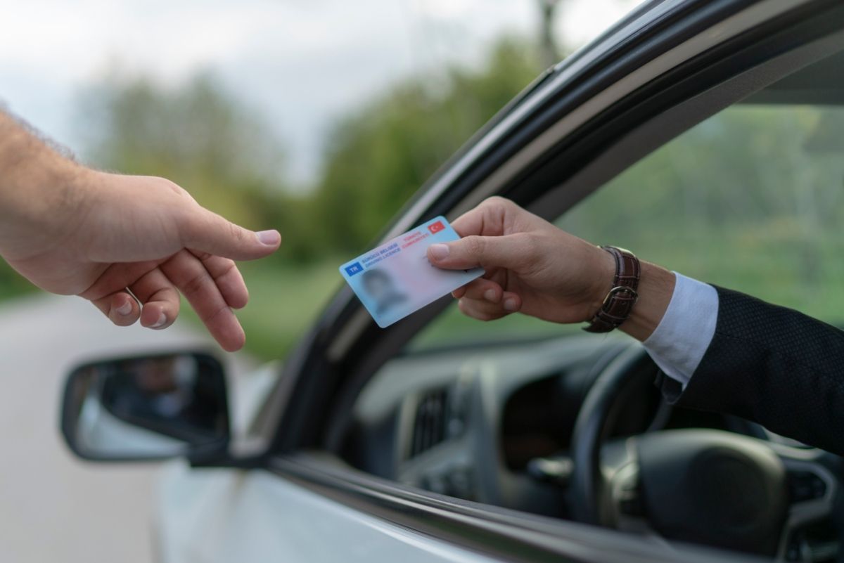 Un conductor mostrando su carnet de conducir a un agente. Fuente: iStock/UfukSaracoglu