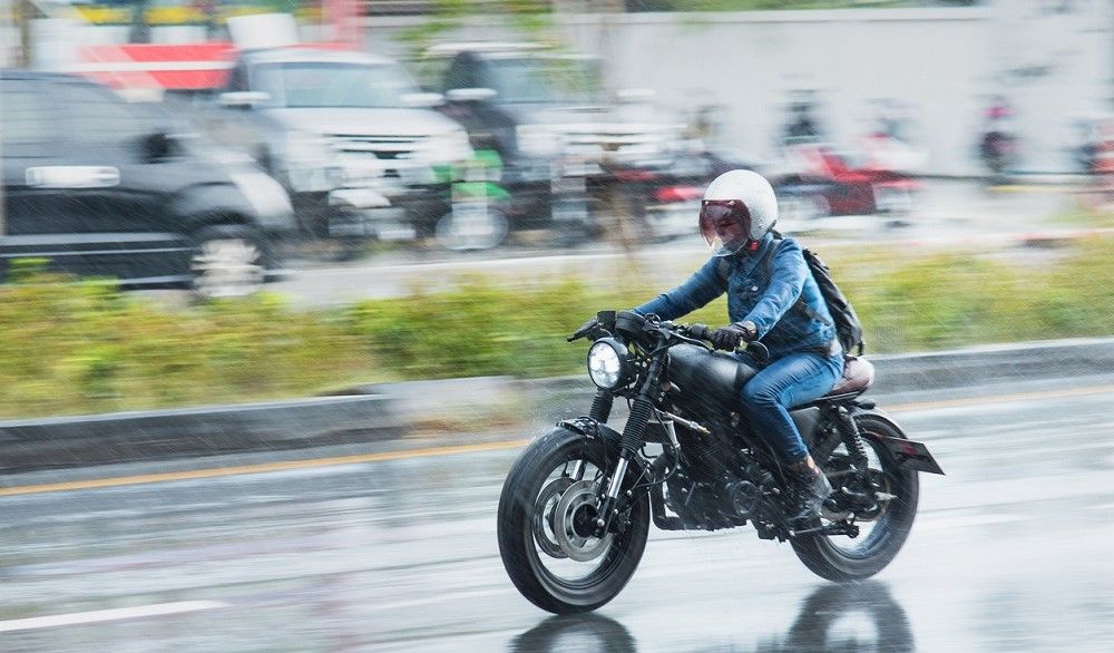 Motorista circulando bajo la lluvia. Fuente: iStock.com/Bubbers13