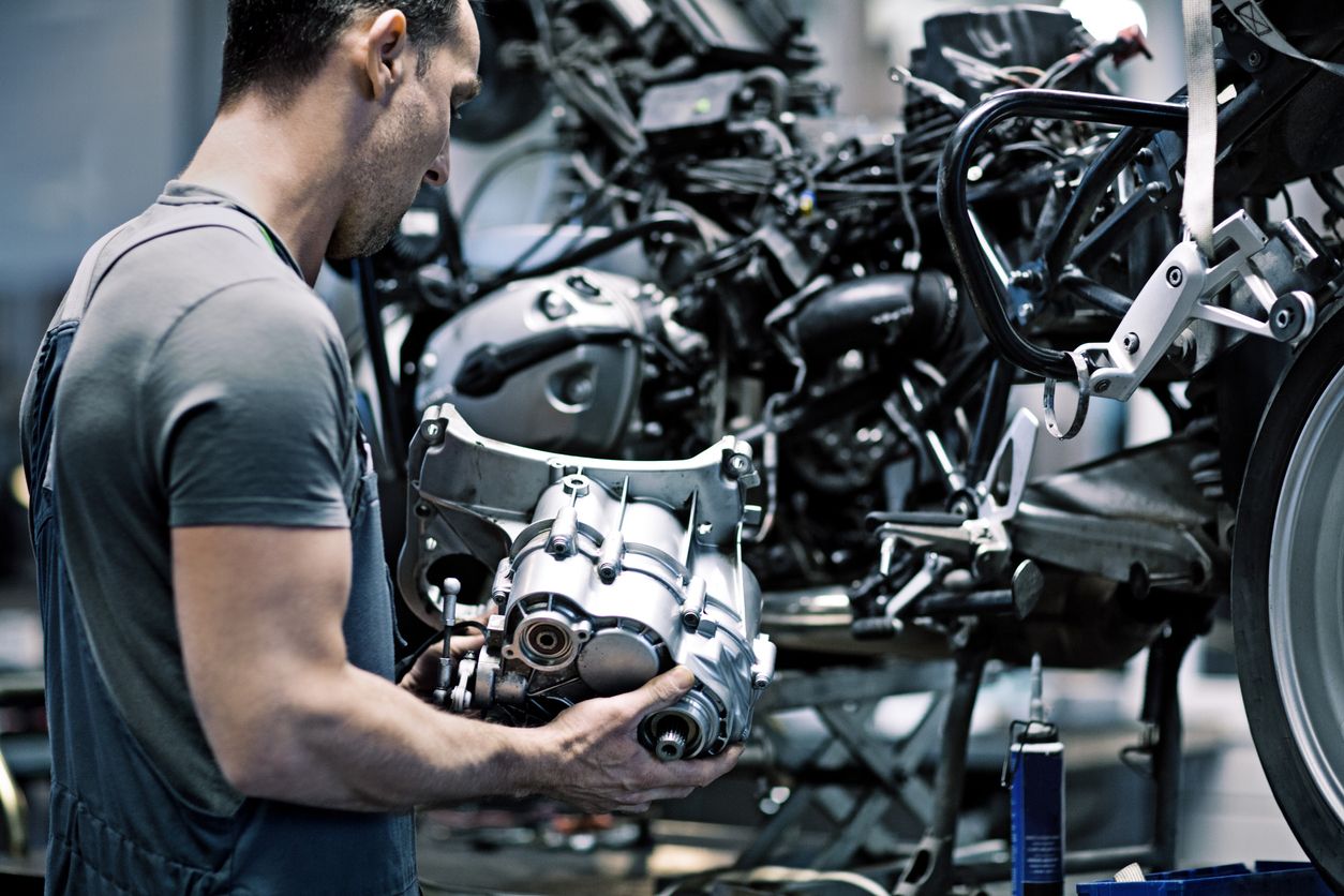 Mecánico inspeccionando la mecánica de la moto. Fuente: iStock/Lorado