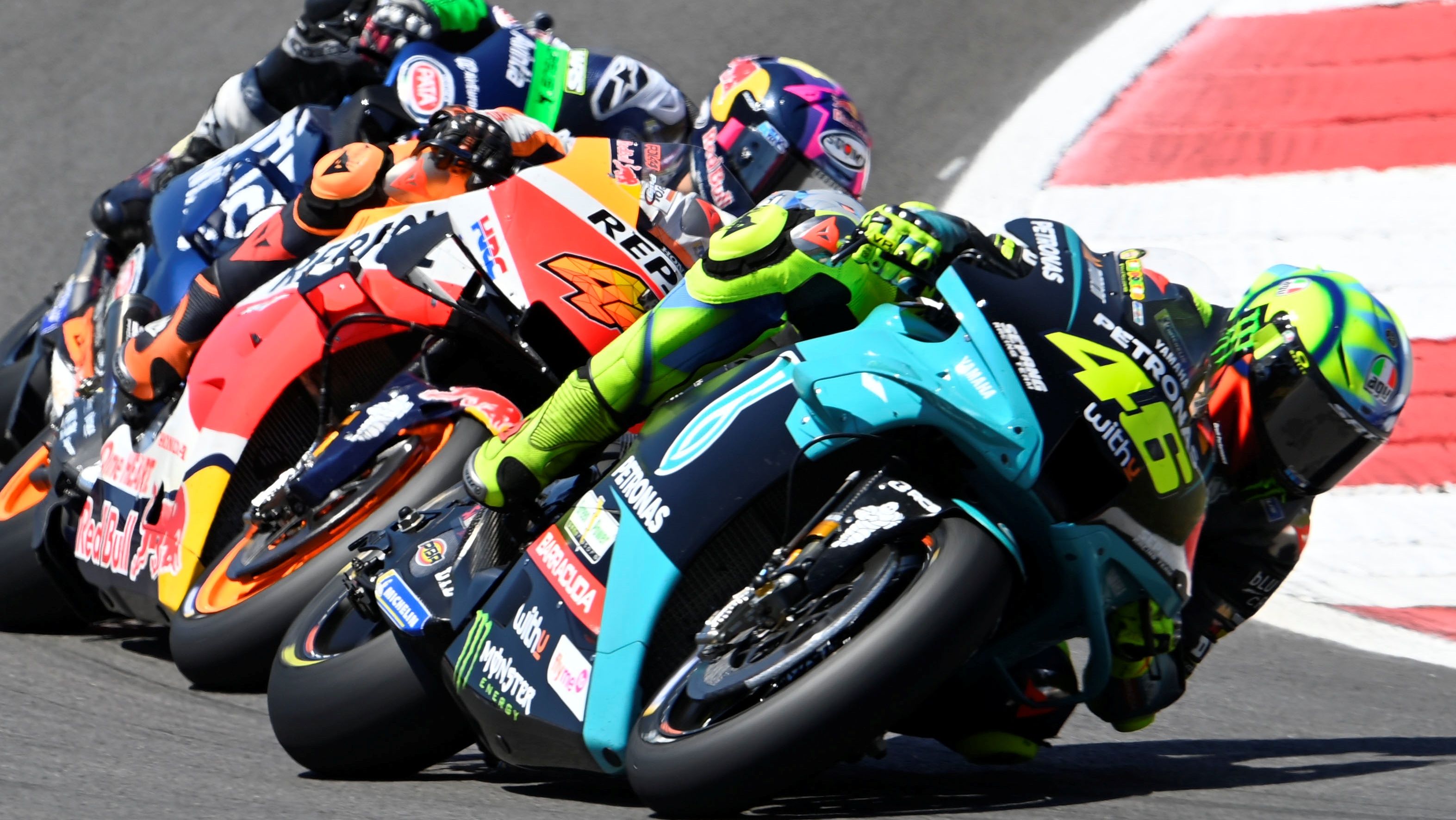 Valentino Rossi con Pol Espargaró y Enea Bastianini totalmente pegados a él