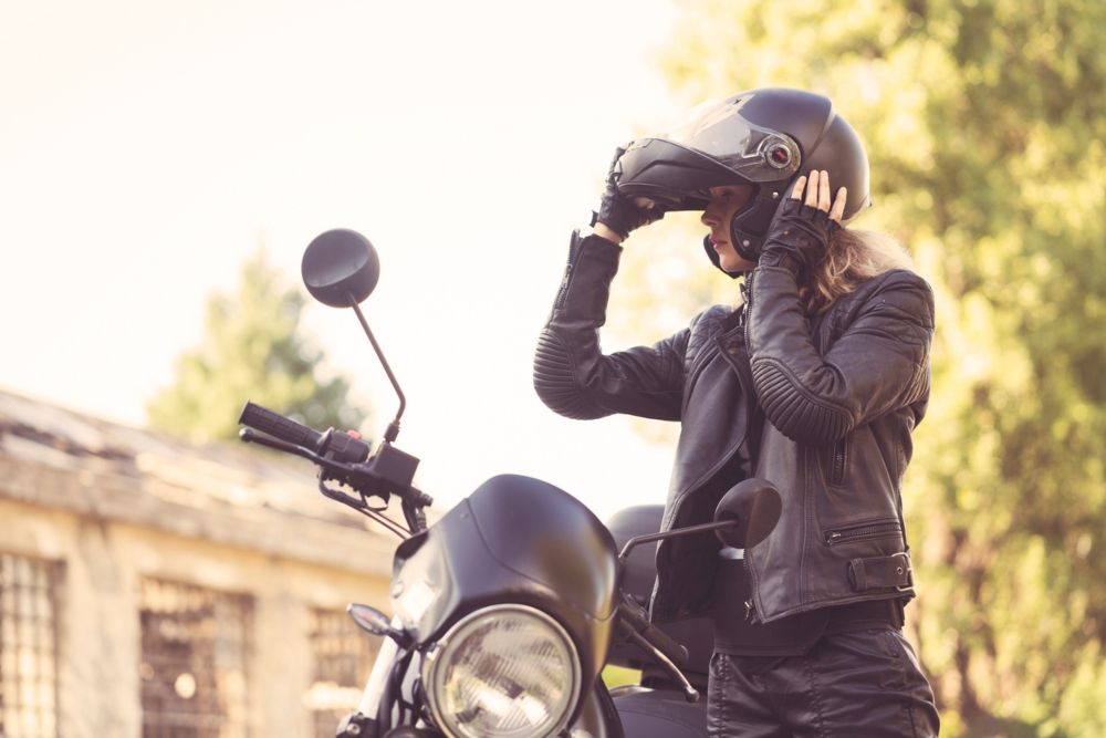 Una joven con su moto tras sacarse el carnet en una de las autoescuelas. Fuente: iStock / Vesnaandji
