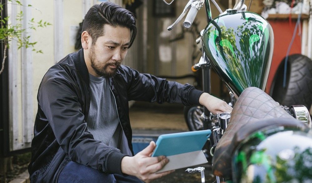 Antes de comprar motos en subastas, hay que revisarlas, tal y como hace este hombre. Fuente: iStock/visualspace