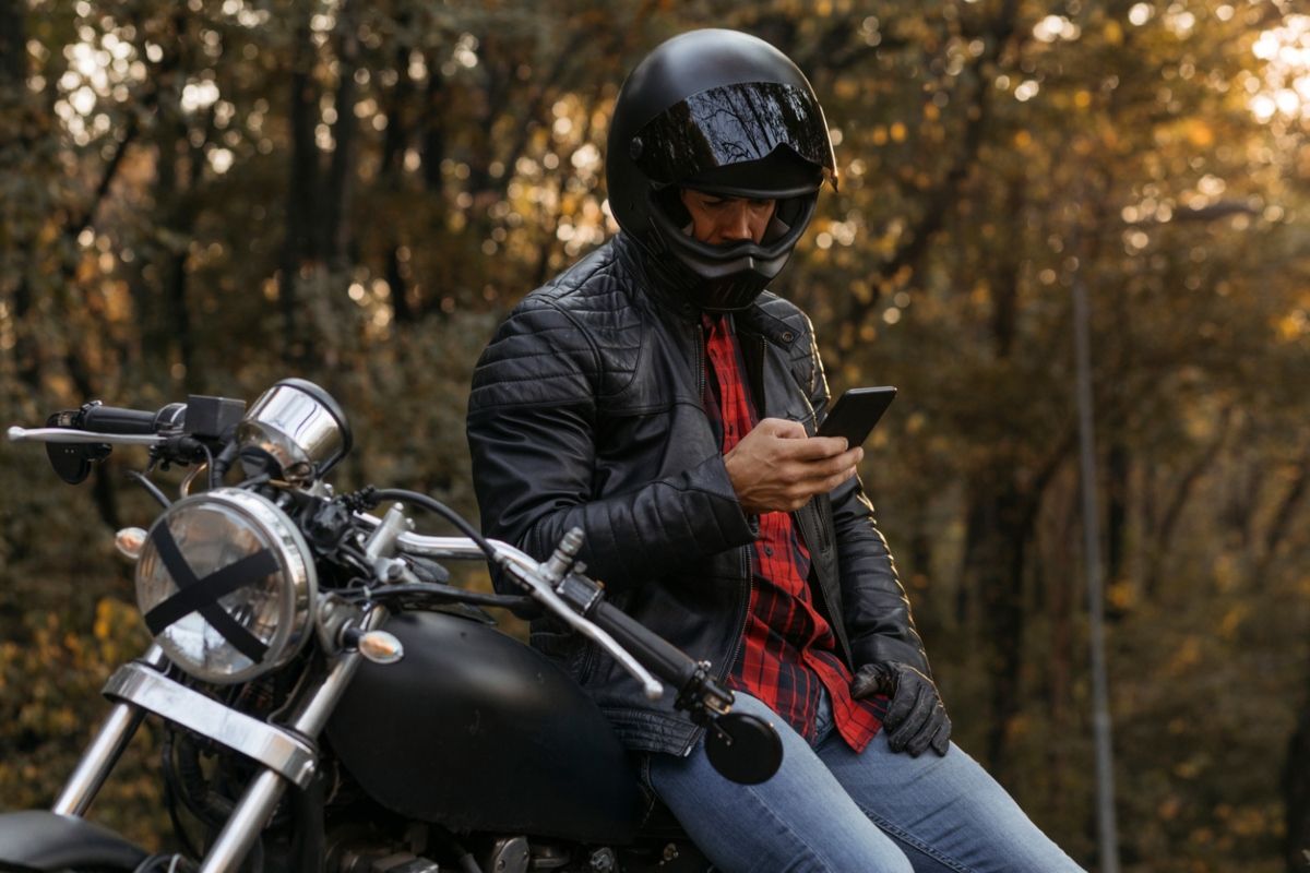 Motorista con móvil que puede llevarse en la moto con un soporte. Fuente: iStock / humanmade