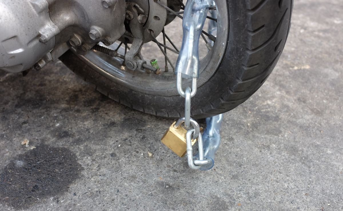 Rueda de una moto con cadena antirrobo. Fuente: iStock / GOLFX