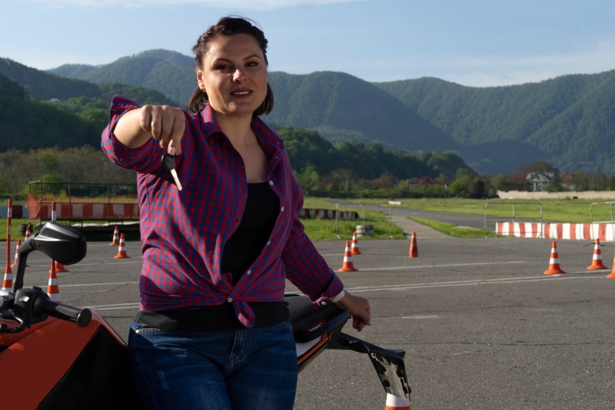 Joven tras sacarse el carnet A1 de moto. Fuente: iStock / Aleksandr Zhurilo.