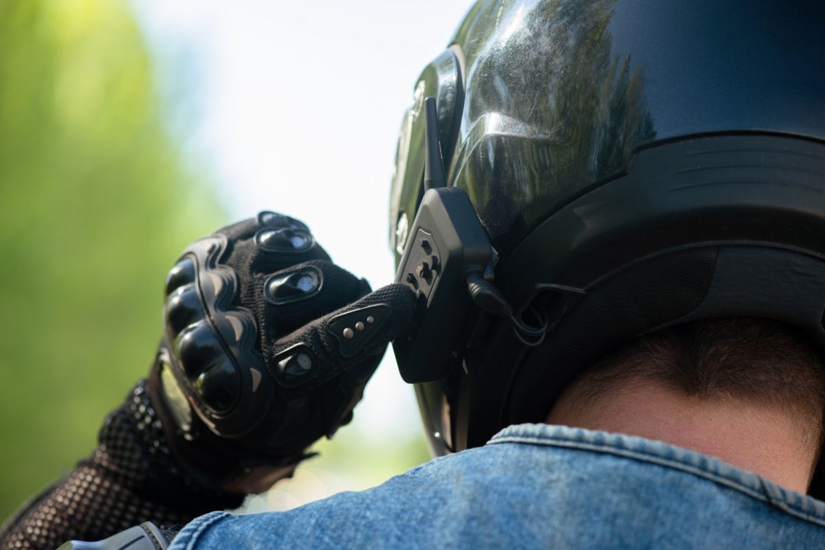 Motorista accionando un intercomunicador del casco. Fuente: IStock / undefined undefined.