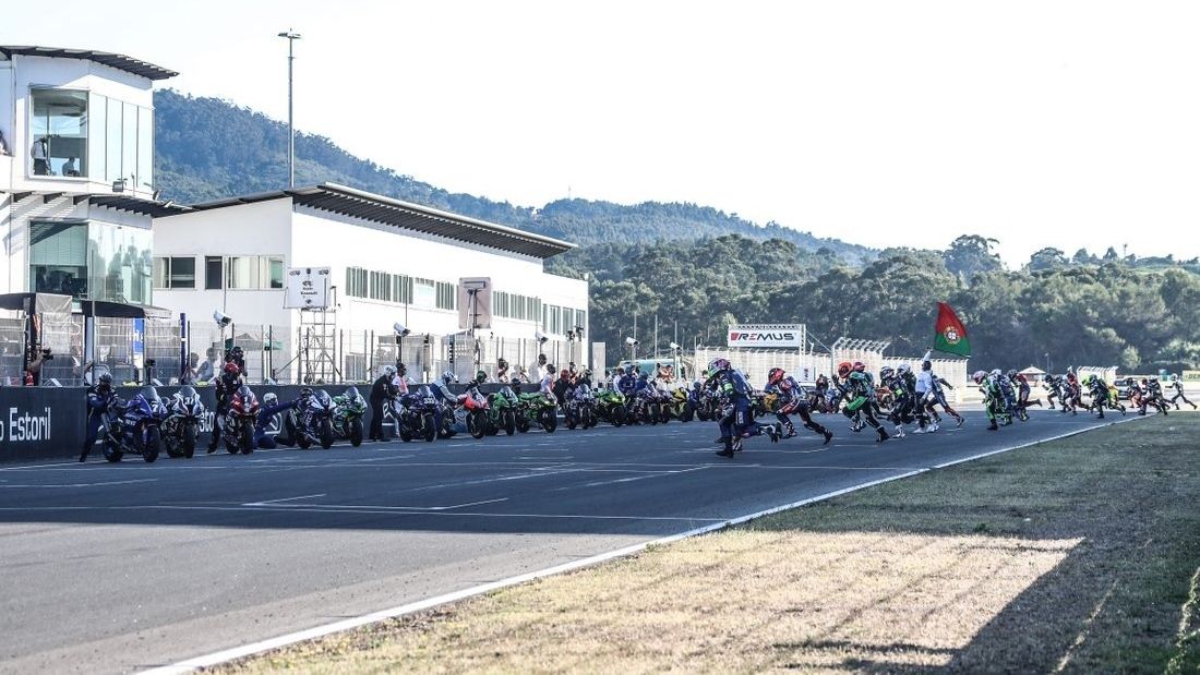 Los pilotos corren a por las motos en la salida