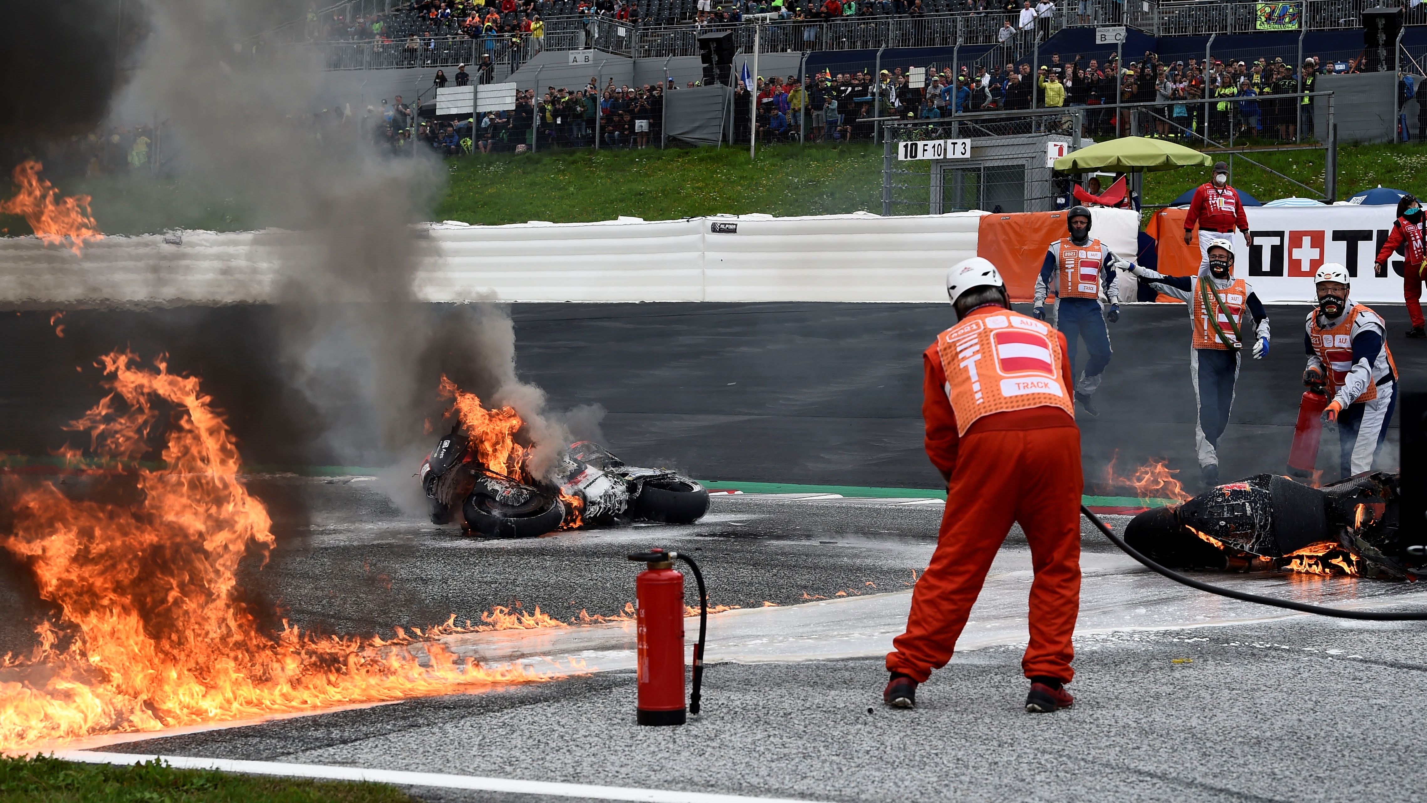 Los marshals se afanan en extinguir el incendio de la KTM de Dani Pedrosa y la Aprilia de Lorenzo Savadori