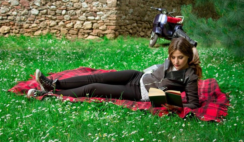 Joven aficionada a las motos leyendo un libro. Fuente: iStock/chabybucko