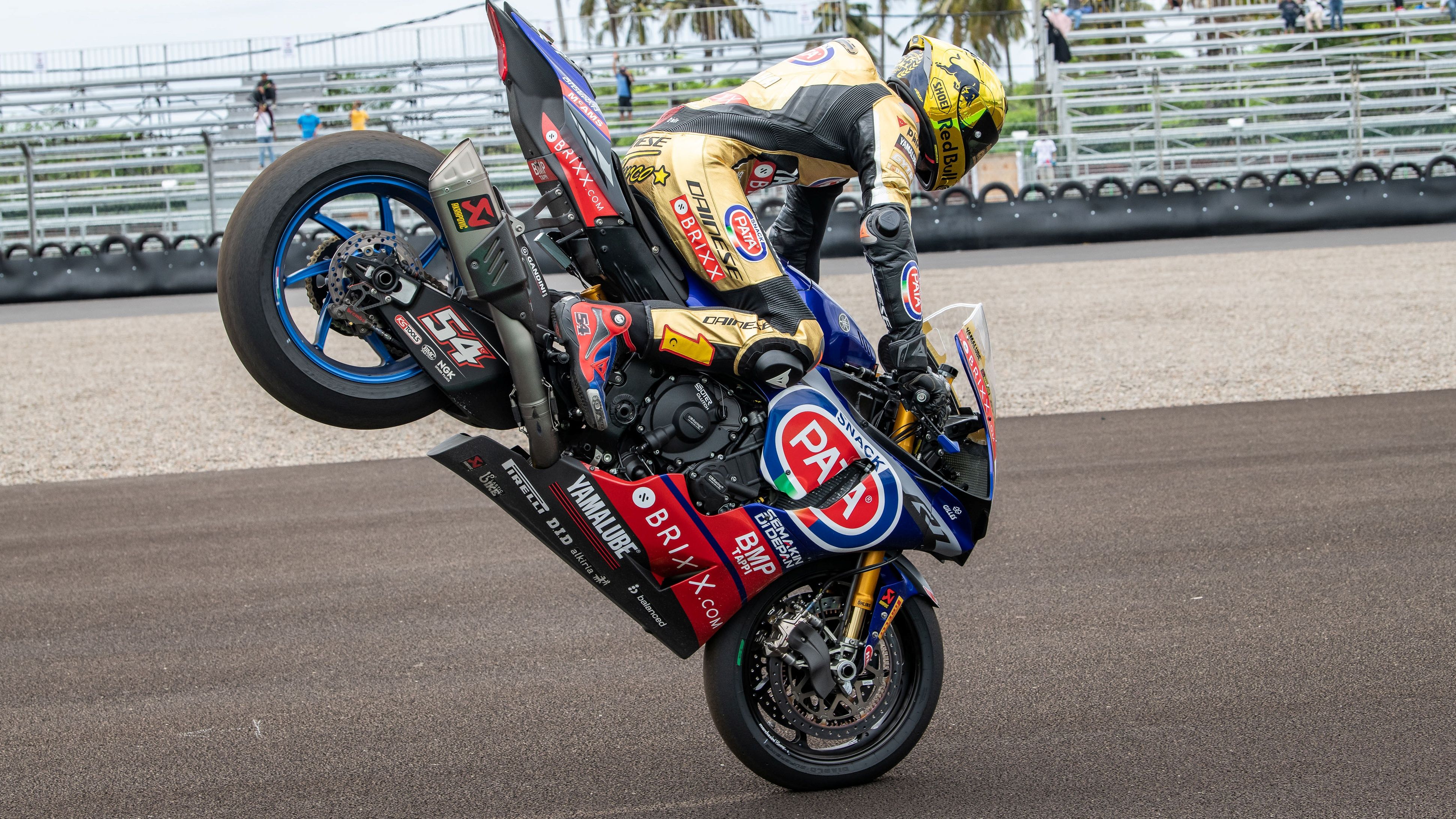 Toprak Razgatlioglu haciendo un stoppie con su mono dorado de campeón
